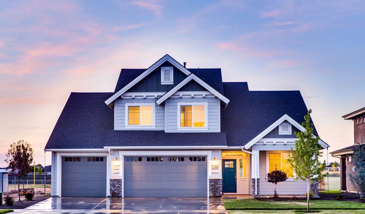 A beautiful home exterior showcasing curb appeal with fresh landscaping, a maintained roof, and a clean driveway—key exterior home improvements for selling your home faster.