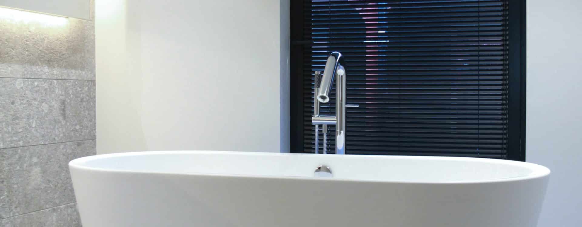 Chic modern bathroom with a white freestanding tub and minimalist aesthetics.
