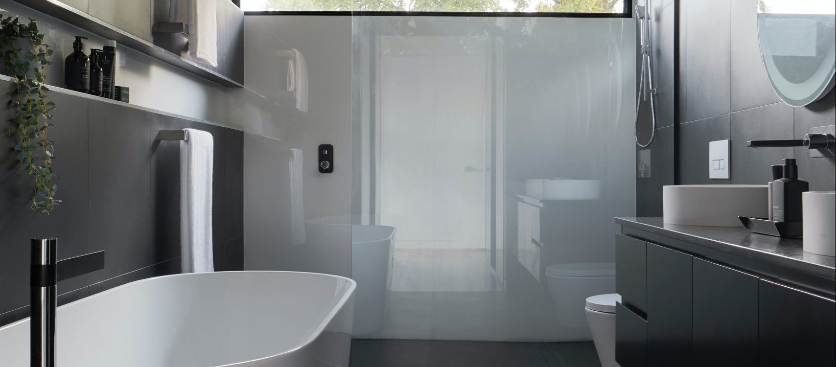 Minimalistic bathroom with a freestanding bathtub and blue accent wall.