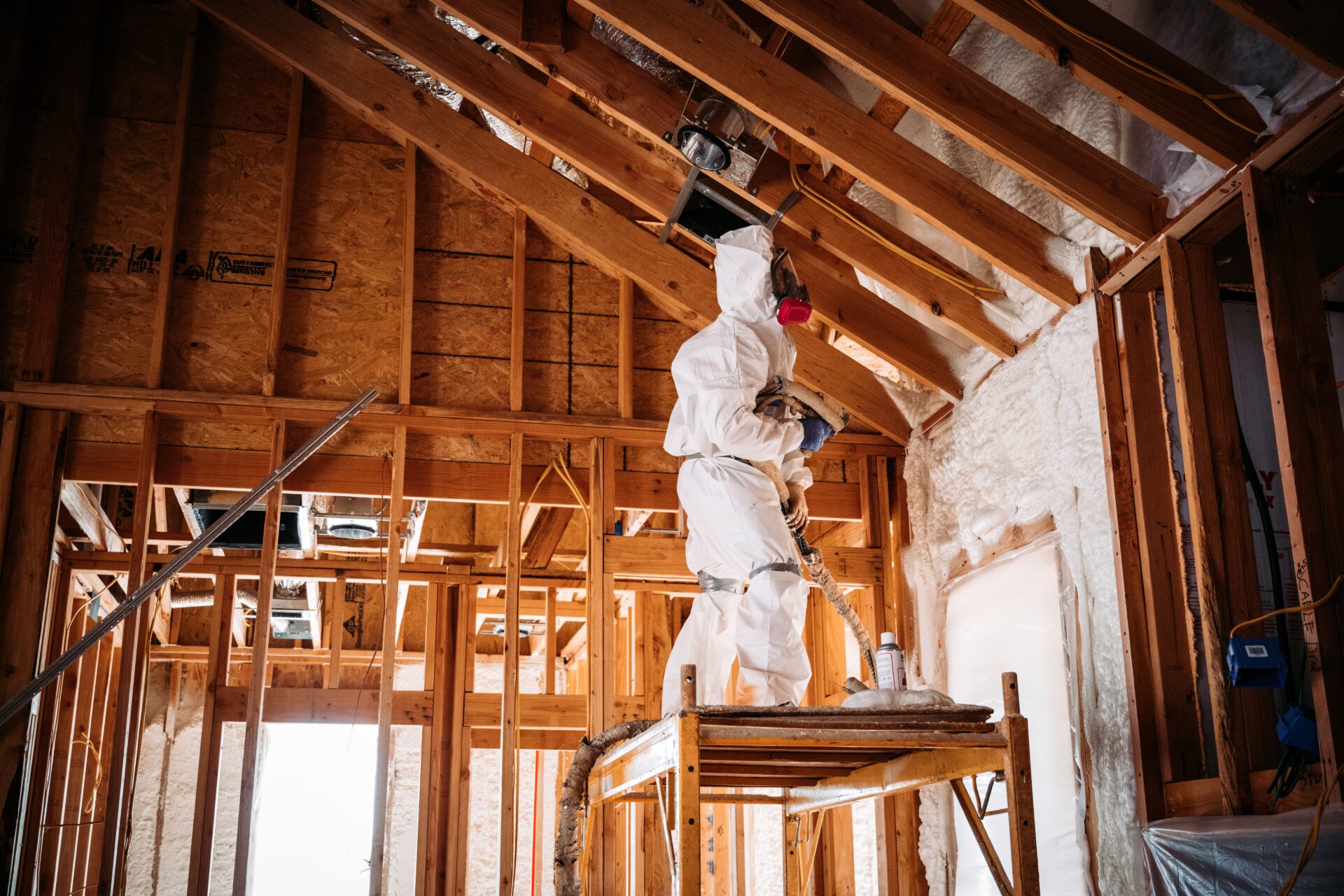 Technician blowing cellulose insulation into an attic
