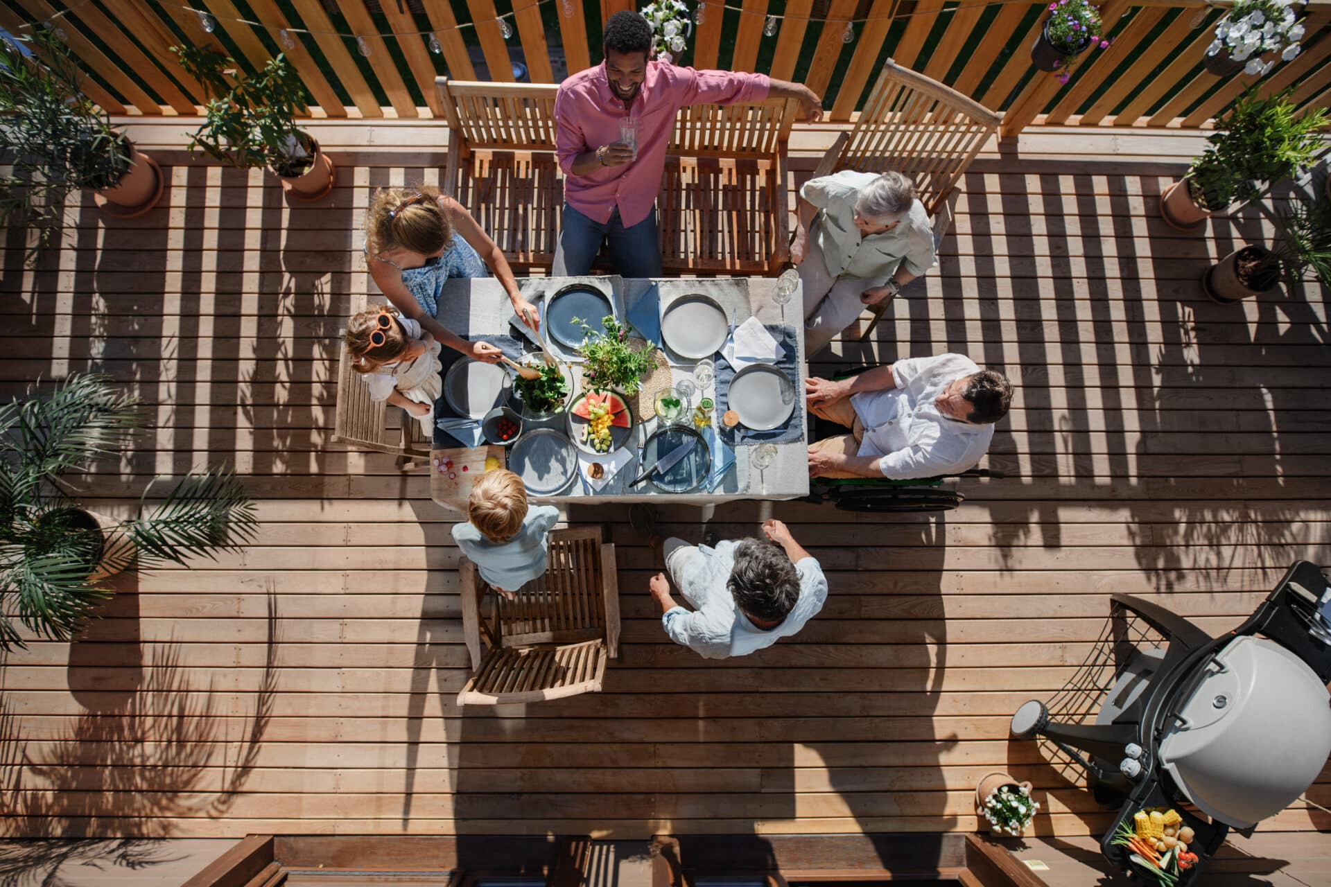 Family enjoying cake together on a sun-lit deck