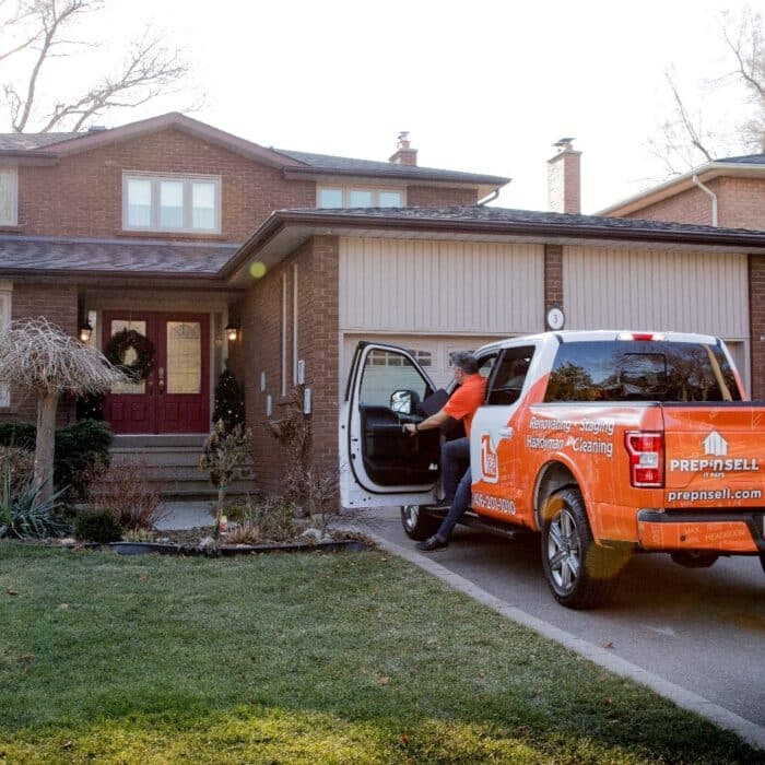 Prep’n Sell home makeover specialist stepping out of branded orange truck in front of a house