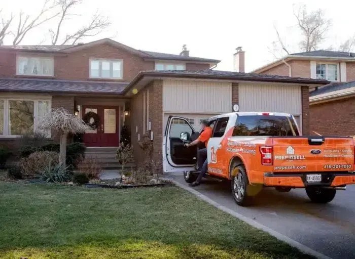 Prep’n Sell home makeover specialist stepping out of branded orange truck in front of a house