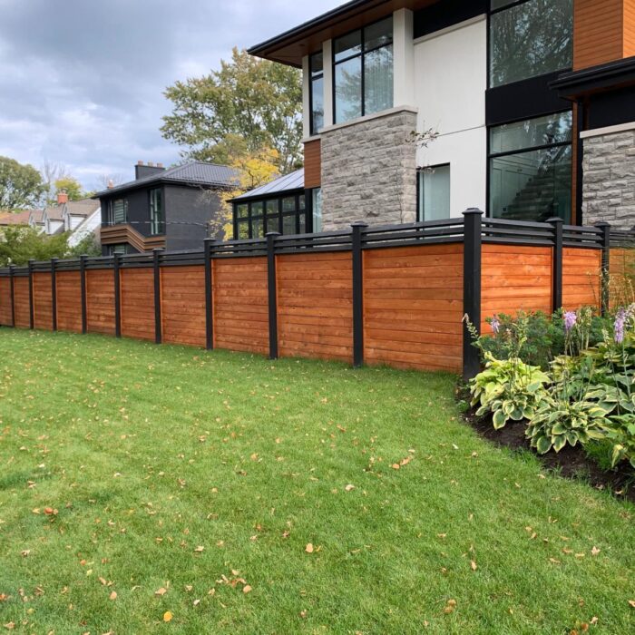 A modern wood-and-black exterior fence enhancing curb appeal for a well-prepared, market-ready home.