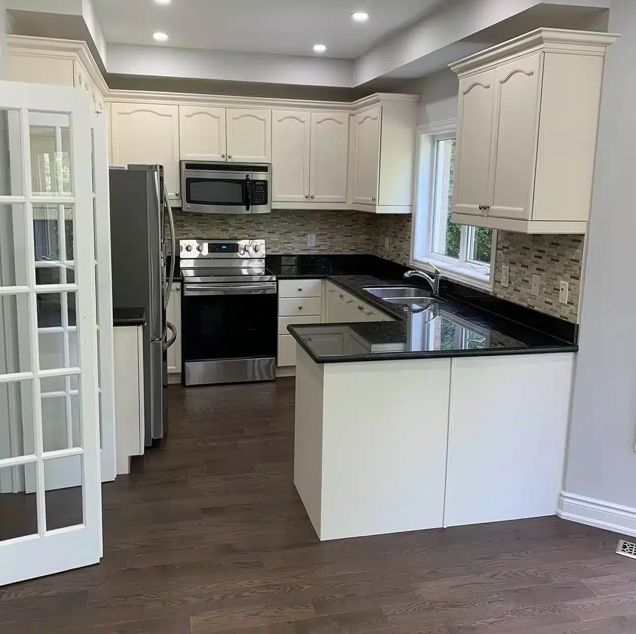 Kitchen after — painted cabinets, new flooring and lighting